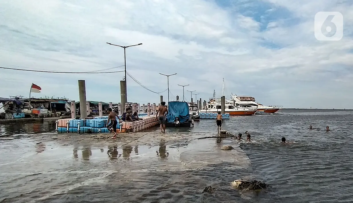 Anak-anak berenang di dermaga saat banjir rob merendam Pelabuhan Kali Adem, Muara Angke, Jakarta, Kamis (22/10/2020). Banjir rob yang merendam kawasan Pelabuhan Kali Adem sejak lima hari lalu dimanfaatkan oleh anak-anak setempat untuk berenang di sekitar dermaga. (merdeka.com/Iqbal S. Nugroho)