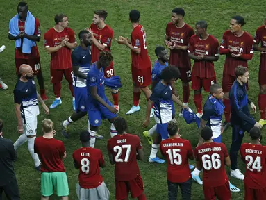 Pemain Chelsea berjalan di depan pemain Liverpool untuk mendapatkan medali setelah pertandingan Piala Super Eropa 2019 di Besiktas Park, di Istanbul (15/8/2019). Chelsea kalah lewat adu penalti atas Liverpool 5-4 (2-2). (AP Photo/Emrah Gurel)