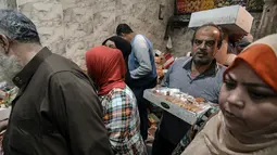 Warga Mesir membeli permen gula tradisional di sebuah toko ibu kota Kairo, Senin (19/11). Permen tradisional yang dibuat dalam berbagai bentuk boneka itu merupakan salah satu sajian rutin warga Mesir dalam perayaan Maulid Nabi. (Mohamed el-Shahed/AFP)