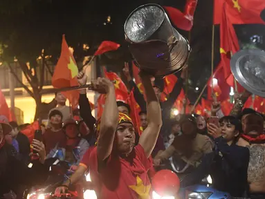 Sejumlah warga konvoi merayakan keberhasilan Vietnam mengalahkan Qatar pada semifinal Piala AFC U-23 di Hanoi, Rabu (23/1/2018). Vietnam berhasil lolos ke final untuk menantang pemenang antara Uzbekistan dan Korea Selatan. (AFP/Hoang Dinh Nam)