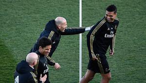 Pelatih Real Madrid, Zinedine Zidane dan gelandang timnya, Casemiro bercanda selama sesi latihan terbuka untuk umum di fasilitas latihan Ciudad Real Madrid, Valdebebas, Senin (30/12/2019). Real Madrid akan menghadapi Getafe pada pertandingan La Liga di laga pembuka tahun 2020. (OSCAR DEL POZO/AFP)