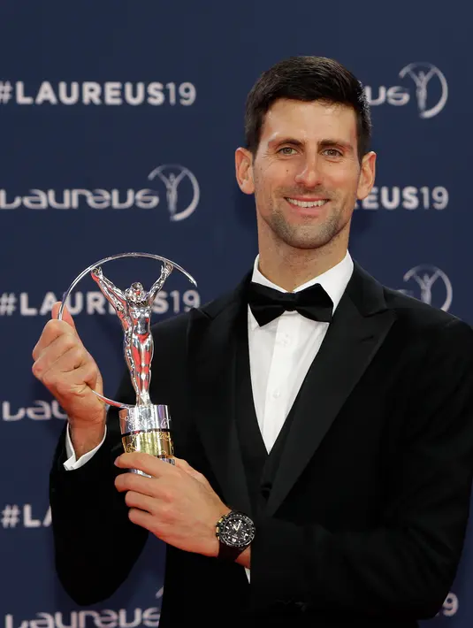 Petenis Serbia, Novak Djokovic berpose dengan trofi World Sportsman of the Year dalam ajang Laureus World Sports Awards 2019 di Monako, Senin (18/2). Djokovic mengalahkan Kylian Mbappe, LeBron James, Luka Modric dan Lewis Hamilton. (AP/Claude Paris)