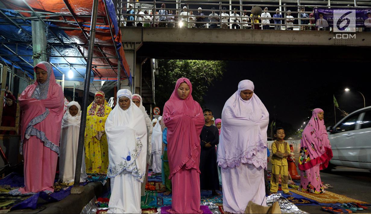 Pemandangan saat jemaah melaksanakan salat tarawih hingga ke badan jalan dan JPO akibat melubernya Musala Miftahul Jannah di Kawasan Pasar Gembrong, Jakarta, Kamis (17/5). (Liputan6.com/JohanTallo)