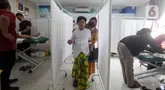 Seorang anak didampingi orang tuanya usai mengikuti sunatan massal yang diselenggarakan oleh Pemerintah Provinsi DKI Jakarta di RSUD Kebayoran Baru, Kamis (26/6/2025). (Liputan6.com/Herman Zakharia)