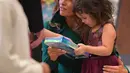 Melania Trump berinteraksi dengan anak-anak saat menghadiri Kampanye Program Korps Marinir AS "Toys For Tots" di Joint Base Anacostia-Bolling, Washington (13/12). (AFP Photo/mandel Ngan)