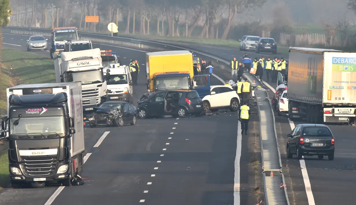 Petugas darurat berada di lokasi tabrakan beruntun di Jalan D12 antara La Roche-sur-Yon dan Les Sables d'Olonne, sebelah barat Prancis, Selasa (20/12). Kecelakaan yang melibatkan sekitar 50 kendaraan itu menewaskan 5 orang. (JEAN-FRANCOIS MONIER/AFP)