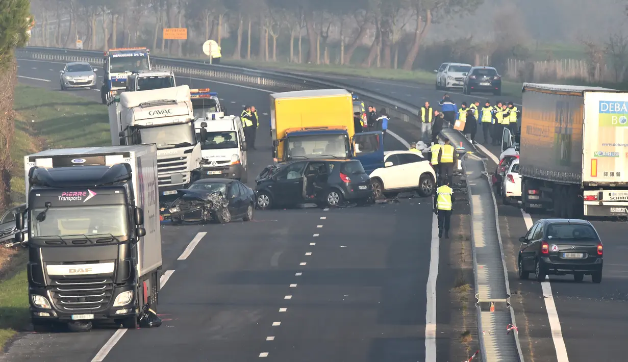 Petugas darurat berada di lokasi tabrakan beruntun di Jalan D12 antara La Roche-sur-Yon dan Les Sables d'Olonne, sebelah barat Prancis, Selasa (20/12). Kecelakaan yang melibatkan sekitar 50 kendaraan itu menewaskan 5 orang. (JEAN-FRANCOIS MONIER/AFP)
