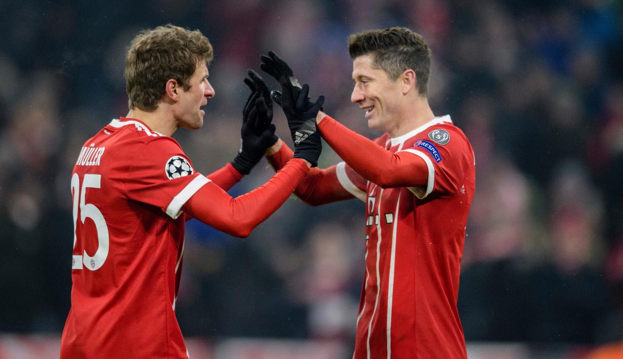 Pemain Bayern Munchen, Robert Lewandowski berselebrasi dengan Thomas Mueller usai mencetak gol ke gawang Besiktas pada pertandingan pertama babak 16 besar Liga Champions di Allianz Arena, Selasa (20/2). Bayern menang telak 5-0. (Matthias Balk/dpa via AP)