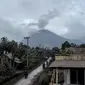 Gunung Semeru menjulang di atas desa Lumajang, Jawa Timur, setelah meletus sehari sebelumnya, Minggu (17/1/2021). Gunung Semeru kembali erupsi dan mengeluarkan awan panas guguran sejauh 4,5 kilometer pada Sabtu (16/1). (Juni Kriswanto / AFP)