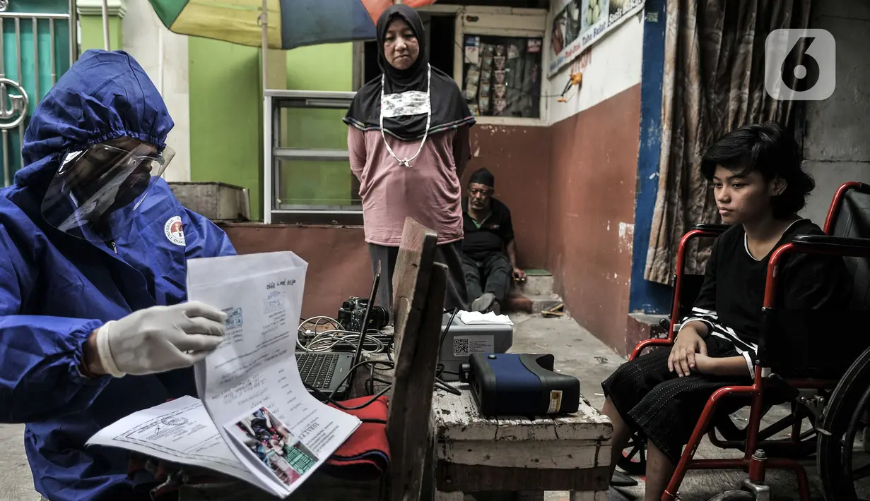 Petugas Disdukcapil Kota Jakarta Utara merekam E-KTP penyandang disabilitas di Pademangan Barat, Jakarta, Kamis (16/7/2020). Program jemput bola ini untuk memudahkan pelayanan administrasi kependudukan bagi penyandang disabilitas, jompo dan orang sakit di masa pandemi. (merdeka.com/Iqbal S. Nugroho)