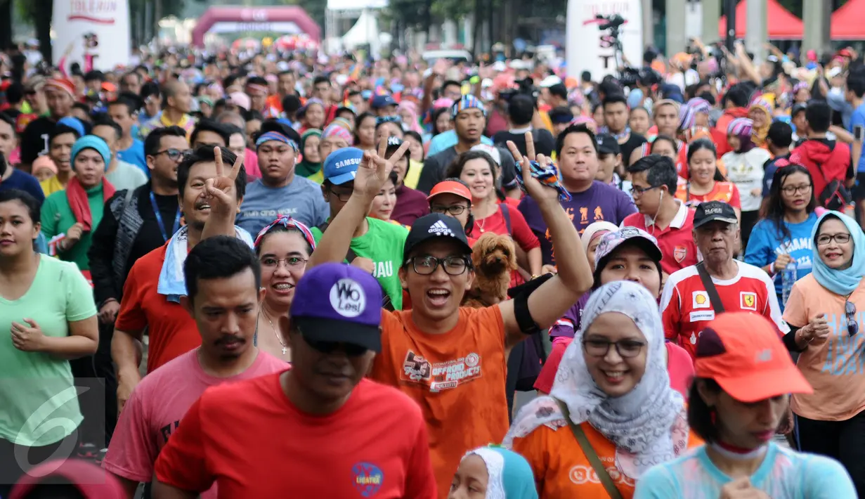 Peserta ToleRun 2016 mengangkat tangan saat memulai lari di Jalan Jend Sudirman, Jakarta, Minggu (20/11). Diikuti ratusan peserta, ToleRun 2016 dilaksanakan serentak di 31 kota di Indonesia. (Liputan6.com/Helmi Fithriansyah)