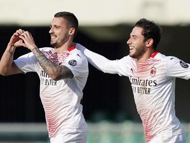 Pemain AC Milan, Rade Krunic, melakukan selebrasi bersama Davide Calabria usai mencetak gol ke gawang Verona pada laga Liga Italia di Stadion Bentegodi, Minggu (7/3/2021). AC Milan menang dengan skor 2-0. (Spada/LaPresse via AP)