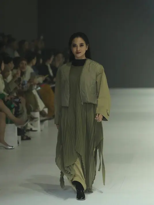 Ririn Ekawati juga hadir menjadi Muse IKYK mengenakan tampil serba hijau army, dengan dress plisket, outer crop top, serta celanany. Dengan mengenakan boots heels hitam. [Daniel Kampua]