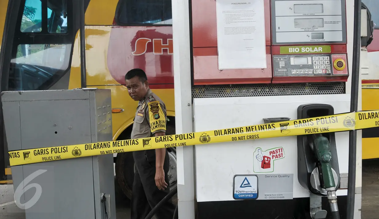 Seorang petugas berjalan dekat mesin pompa solar yang dipasangi garis polisi di SPBU Jalan Juanda, Depok, Senin (14/11). Polresta Kota Depok menyegel dan menutup sementara SPBU itu lantaran diduga mencampur solar dengan air. (Liputan6.com/Yoppy Renato)