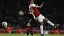 Duel udara antara Aubameyang dan Rami Bensebaini pada leg kedua,babak 16 besar Liga Europa yang berlangsung di Stadion Emirates, London, Jumat (15/3). Arsenal menang 3-0 atas Rennes. (AFP/Ian Kington)