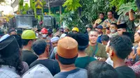 Keluarga korban memaksa masuk TKP bangunan ambruk di Ponpes Al Khoziny Sidoarjo, mereka emosi ingin membantu dalam pencarian korban karena menilai kerja Tim SAR lamban. (Liputan6.com/ Zainul Arifin)