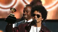Penyanyi R&B, Bruno Mars mengangkat trofi Song of The Year pada ajang Grammy Awards 2018 di New York City, Minggu (28/1). Tak kurang dari 6 piala Grammy berhasil dibawa pulang termasuk song of the year untuk That’s What I Like. (Matt Sayles/Invision/AP)