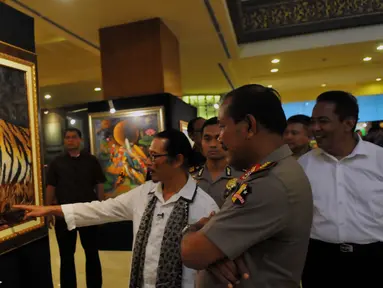 Kapolri Jenderal Badrodin Haiti menyimak penjelasan Pelukis Cak Kandar di Hotel Sultan Jakarta, Senin (21/3/2016). Kehadiran Kapolri Badrodin Haiti untuk meresmikan Pameran Lukisan Dua Tanda. (Liputan6.com/Faisal R Syam)