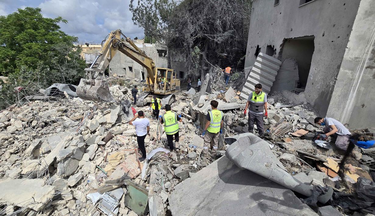 Para pekerja pertahanan sipil Lebanon menyisir reruntuhan, sehari setelah serangan Israel di desa Deir Qanun al-Nahr, Lebanon Selatan, pada Rabu 20 Mei 2026. (KAWNAT HAJU/AFP)