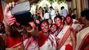 Wanita Hindu berselfie didekat patung dewi Durga pada hari terakhir festival Durga Puja di Mumbai, India (11/10). Festival ini semakin populer pada masa Kemaharajaan Britania di Bengali. (AP Photo/Rajanish Kakade)