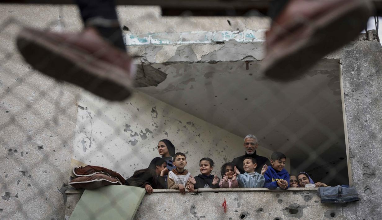 Pertandingan sepak bola di tengah reruntuhan menjadi simbol ketangguhan warga Palestina di kota Gaza. Tampak dalam foto, warga Palestina menyaksikan pertandingan sepak bola lima lawan lima di tengah reruntuhan bangunan yang hancur di Kota Gaza pada Senin 9 Februari 2026. (Omar AL-QATTAA/AFP)