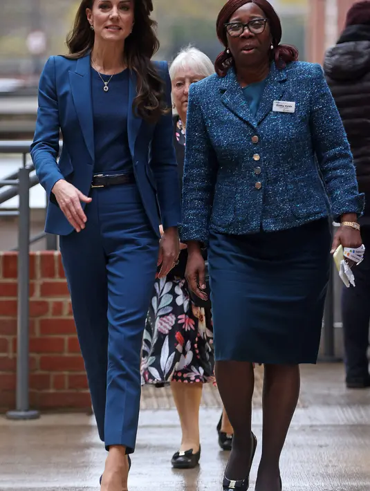 Mengenakan setelan celana biru tua rancangan Sarah Burton untuk Alexander McQueen, sang Putri tampak tenang saat berbicara dengan staf dan pasien yang mengakses fasilitas baru tersebut. (Ian Vogler / POOL / AFP)