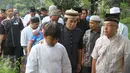 Ketegaran komedian Komeng dan putranya, Ganteng, seusai pemakaman anak ketiganya, Cantika Alhayu Aldi, di Pemakaman Keluarga Citeureup, Bogor, Minggu (28/8). Anak ketiga Komeng dari kembar tiga itu meninggal di usia 10 tahun (Liputan6.com/Herman Zakharia)