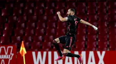 Pemain Real Madrid Karim Benzema melakukan selebrasi usai mencetak gol ke gawang Granada pada pertandingan La Liga di Stadion Los Carmenes, Granada, Spanyol, Kamis (13/5/2021). Real Madrid menang telak 4-1 atas Granada. (AP Photo/Fermin Rodriguez)