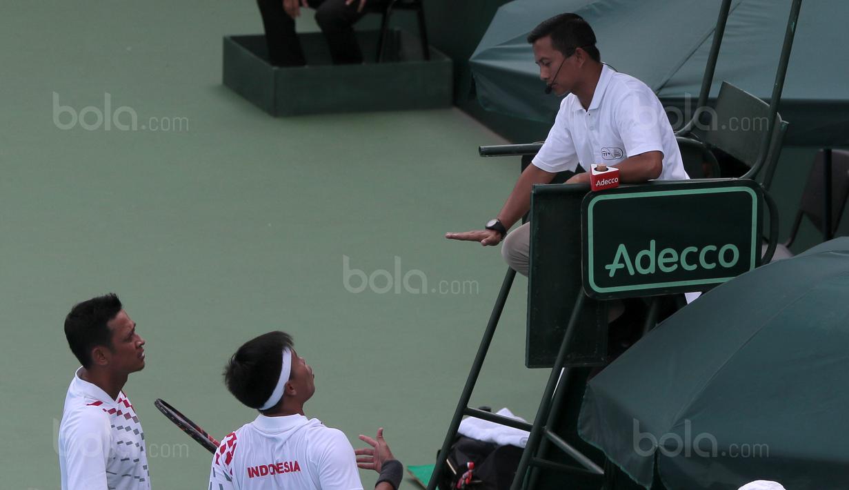 David Agung Susanto (tengah) melakukan protes kepada wasit saat melawan petenis Filipina, Jeson Patrombon pada Piala Davis 2018 grup dua Asia/Oceania di Senayan, Jakarta, Sabtu (3/2/2018). David menang 6-2, 7-5. (Bola.com/Nick Hanoatubun)