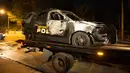Mobil polisi Georgia berada di atas truk setelah dibakar pengunjuk rasa di depan kantor polisi di kampus di Atlanta, AS (18/9). Tiga orang ditangkap saat demonstrasi berlangsung. (Foto AP / Kevin D. Liles)