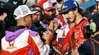 Pembalap Ducati Lenovo, Francesco Bagnaia (kanan), mendapatkan selamat dari Jorge Martin yang merupakan rivalnya musim ini setelah balapan MotoGP Valencia, Minggu (26/11/2023). (AFP/Javier Soriano)
