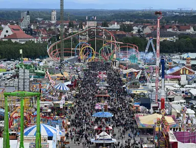 Pemandangan menunjukkan pengunjung berjalan di tempat pekan raya Theresienwiese selama festival bir Oktoberfest di Munich, Jerman selatan (20/9/2022). Festival Bir yang terkenal di dunia ini akan berlangsung hingga 3 Oktober 2022 tanpa batasan akses, setelah dua hari terakhir edisi tahun telah dibatalkan karena pandemi coronavirus. (AFP/Christof Stache)