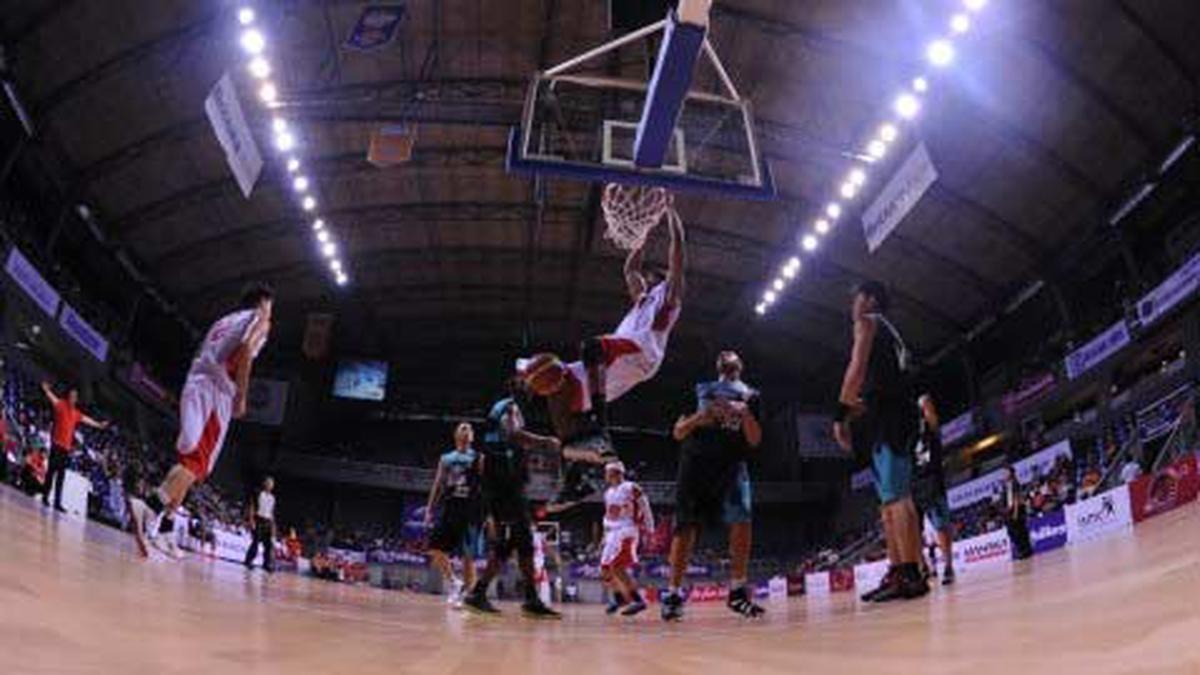 Pebasket Indonesia Warrior Larry Jonathan Smith (tengah) melakukan slam dunk saat pertandingan