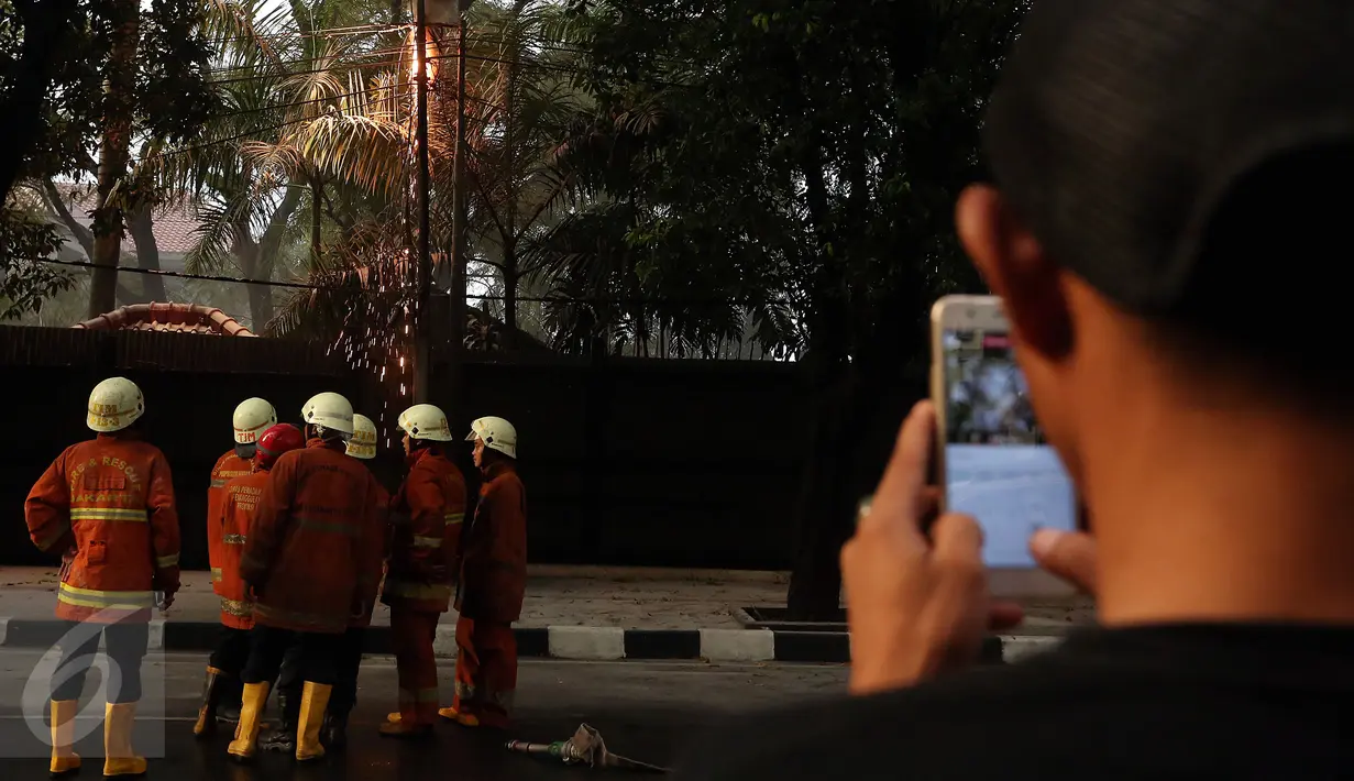 Petugas kebakaran berusaha memantau percikan api yang keluar dari kabel listrik setelah hujan deras mengguyur sore ini, di Jalan Imam Bonjol No 2, Jakarta, Selasa (28/3). (Liputan6.com/JohanTallo)