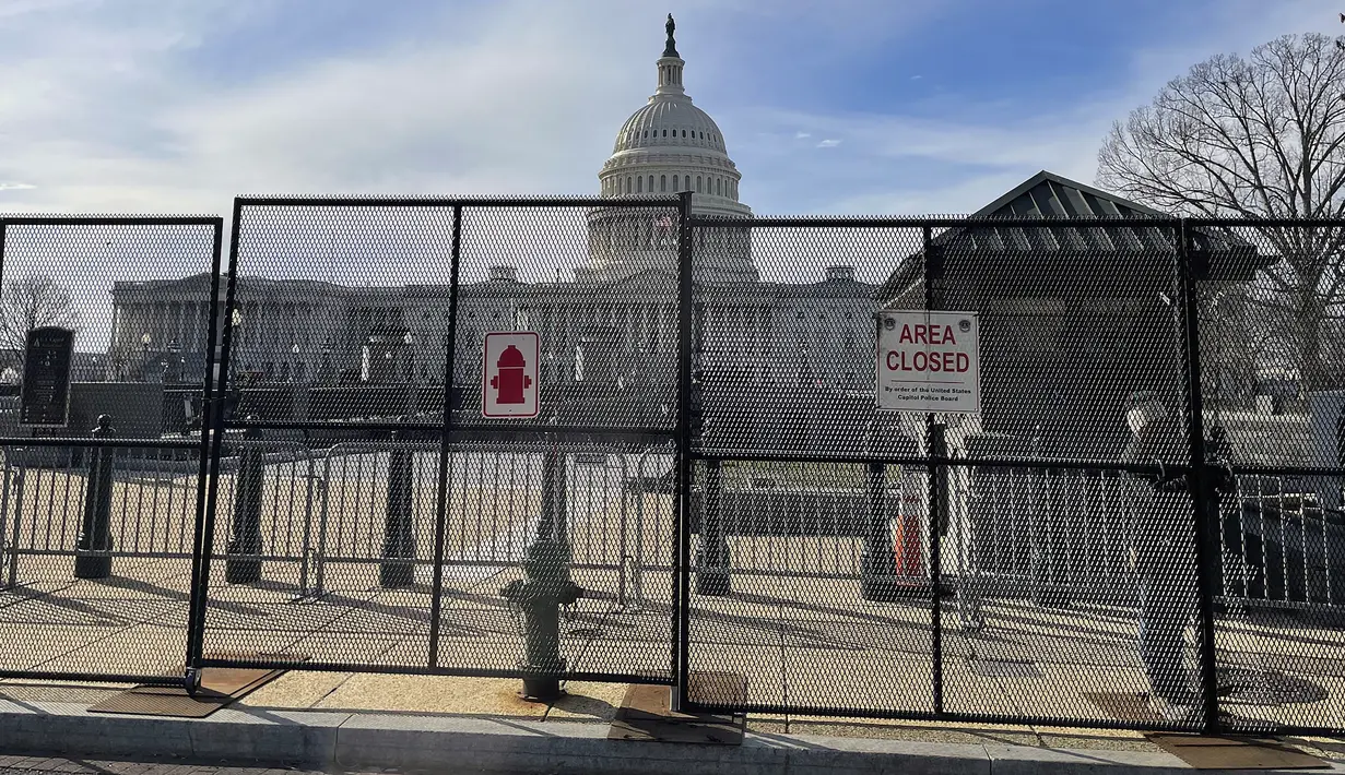 Gedung Capitol AS terlihat di belakang pagar keamanan di Capitol Hill di Washington, Minggu (5/2/2023). Pejabat intelijen di departemen kepolisian memperingatkan dalam email yang diedarkan ke kepolisian bahwa tingkat ancaman tetap tinggi menjelang pidato tahunan Presiden Joe Biden yang ditetapkan pada Selasa (7/3) malam waktu AS. (AP Photo/Anna Johnson)