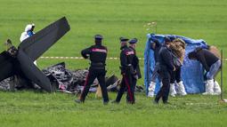 Polisi forensik, Carabinieri, dan prajurit angkatan udara memeriksa sisa-sisa yang terbakar salah satu dari dua pesawat U-208 Angkatan Udara Italia yang jatuh di Guidonia, di pinggiran Roma, Selasa (7/3/2023). Empat pesawat terbang dalam formasi ketika dua pesawat bertabrakan, kata saksi mata kepada media setempat. (AP Photo/Andrew Medichini)