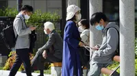 Orang-orang yang mengenakan masker pelindung untuk membantu mengekang penyebaran virus corona COVID-19 mengunjungi taman di Tokyo, Jepang, Kamis (15/4/2021). Tokyo mengonfirmasi lebih dari 700 kasus baru COVID-19 pada 15 April 2021. (AP Photo/Eugene Hoshiko)