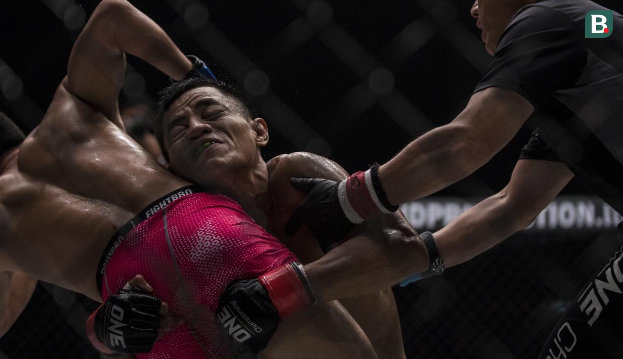 Atlet MMA Indonesia, Stefer Rahardian, menatik badan dari atlet MMA China, Peng Xue Wen, pada kelas strawweight di JCC Senayan, Jakarta, Sabtu (22/9/2018). Stefer Rahardian kalah dari Peng Xue Wen. (Bola.com/Vitalis Yogi Trisna)
