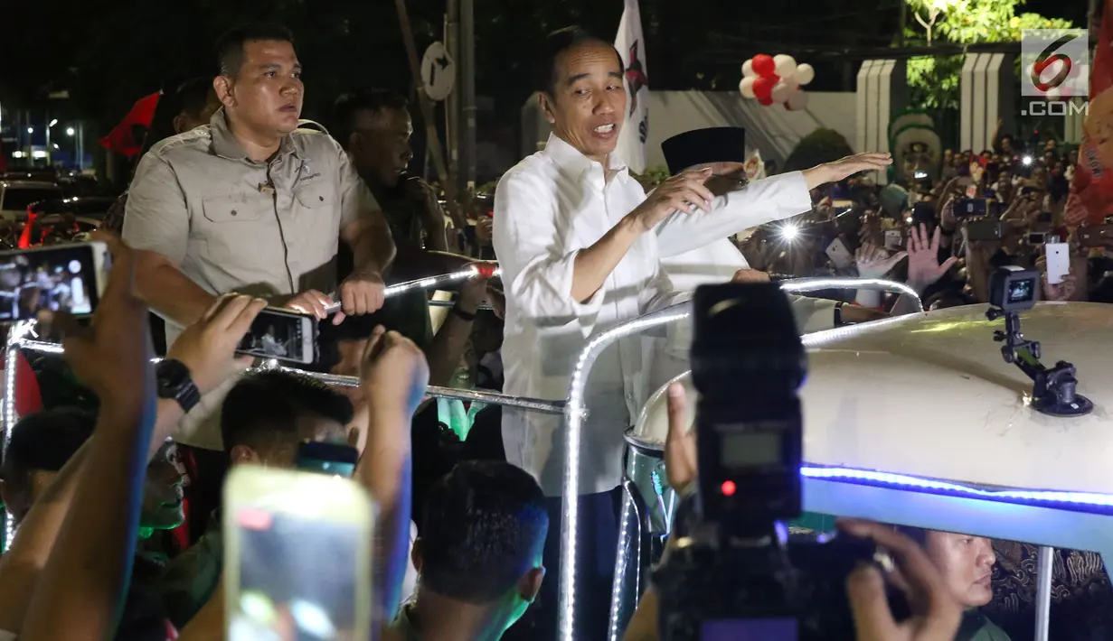 Calon Presiden RI Petahana, Joko Widodo bersama Cawapres Ma’ruf Amin menyapa pendukungnya saat berada di atas jeep menuju gedung KPU dari Tugu Proklamasi, Jakarta, Jumat (21/9). (Liputan6.com/Helmi Fithriansyah)