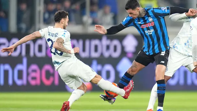Pemain Inter Milan, Hakan Calhanoglu (kiri), berebut bola dengan pemain Atalanta, Gianluca Scamacca