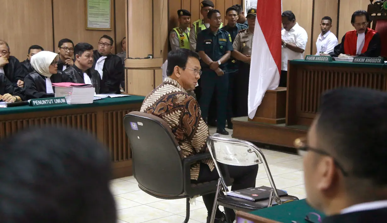 Basuki Tjahaja Purnama atau Ahok mendengarkan pembacaan dakwaan oleh JPU dalam sidang perdana kasus dugaan penistaan agama di PN Jakarta Utara, Selasa (13/12). Sidang Ahok dipimpin oleh Ketua Majelis Hakim Dwiarso Budi Santiarto. (TATAN SYUFLANA/POOL/AFP)