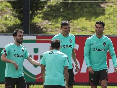 (Dari kiri) Pemain timnas Portugal Bernardo Silva, Joao Palhinha dan Cristiano Ronaldo mengambil bagian dalam sesi latihan di kamp pelatihan "Cidade do Futebol" Portugal di Oeiras, di pinggiran Lisbon, Sabtu (4/6/2022). Portugal akan menjamu Swiss pada matchday 2 Grup 2 UEFA Nations League A 2022/2023, Senin 6 Juni 2022 dini hari WIB di Estadio Jose Alvalade. (CARLOS COSTA / AFP)