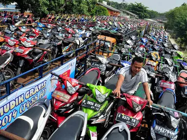 Petugas menata motor milik para peserta mudik gratis dari Kemenhub di Lapangan Gudang Bulog, Jakarta, Rabu (23/7/14). (Liputan6.com/Faizal Fanani)
