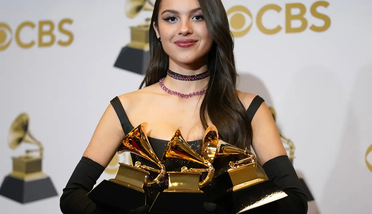 Olivia Rodrigo berpose dengan piala penghargaan Best Pop Vocal Album, Best New Artist, dan Best Pop Solo Performance pada ajang Grammy Awards 2022 di MGM Grand Garden Arena, Las Vegas, Amerika Serikat, 3 April 2022. (AP Photo/John Locher)