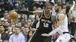 Pemain San Antonio Spurs, LaMarcus Aldridge (12) mencoba melewati adangan pemain Dallas Mavericks, Salah Mejri (50) pada laga NBA Basketball game di American Airlines Center, Dallas, (14/11/2017). Spurs menang 97-91. (AP/LM Otero)