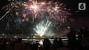 Warga menyaksikan pesta kembang api saat perayaan malam puncak Tahun Baru 2023 di Danau Archipelago, Taman Mini Indonesia Indah (TMII), Jakarta, Minggu (1/1/2023). Danau Archipelago TMII menjadi pusat pesta kembang api di malam tahun baru 2023. (Liputan6.com/Herman Zakharia)