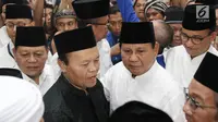 Bakal Calon Presiden, Prabowo Subianto didampingi Wakil Ketua Majlis Syuro PKS Hidayat Nur Wahid berjalan keluar dari Masjid Sunda Kelapa menuju Gedung KPU RI untuk mendaftarkan diri sebagai capres, di Jakarta, Jumat (10/8). (Liputan6.com/Herman Zakharia)