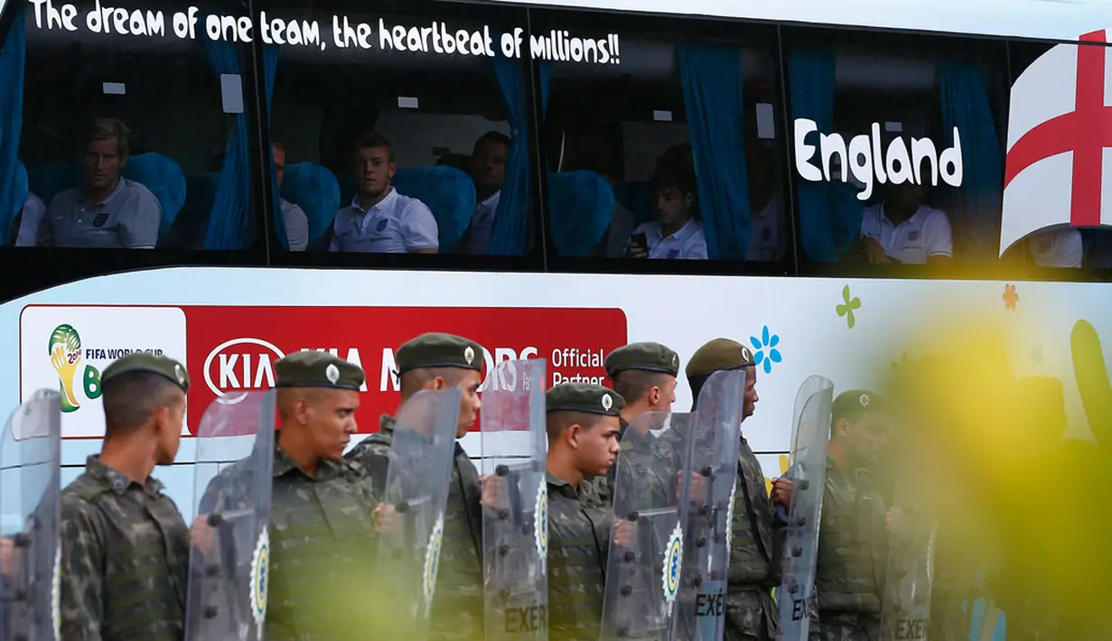 Pasukan militer Brasil membuat barikade pagar betis untuk mengamankan bis yang membawa Timnas Inggris menuju hotel di Rio de Janeiro, Brasil, (8/6/2014). (REUTERS/Darren Staples)