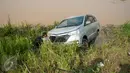 Petugas memasangkan rantai penarik untuk mengevakuasi mobil yang terperosok di saluran Inspeksi Kalimalang, Jabar, Minggu (7/5). Penyebab kecelakaan itu diduga pengemudi mengantuk dan berusaha menghindari pengendara motor. (Liputan6.com/Gempur M Surya)