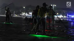 Sejumlah peserta mengikuti night paddling di Ancol, Jakarta, Sabtu (18/5/2019). Indonesia menjadi tuan rumah perhelatan internasional BPJS Ketenagakerjaan Belitong Geopark International SUP (Stand Up Paddleboard) and Kayak Marathon (BGISKM) 2019 di Bangka Belitung. (Liputan6.com/Herman Zakharia)